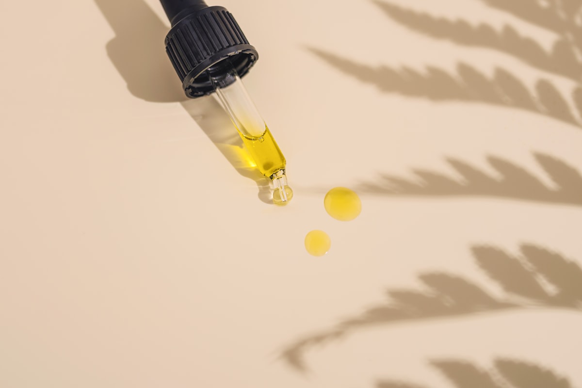 CBD oil dropper bottle next to a digital scale on a clean white surface